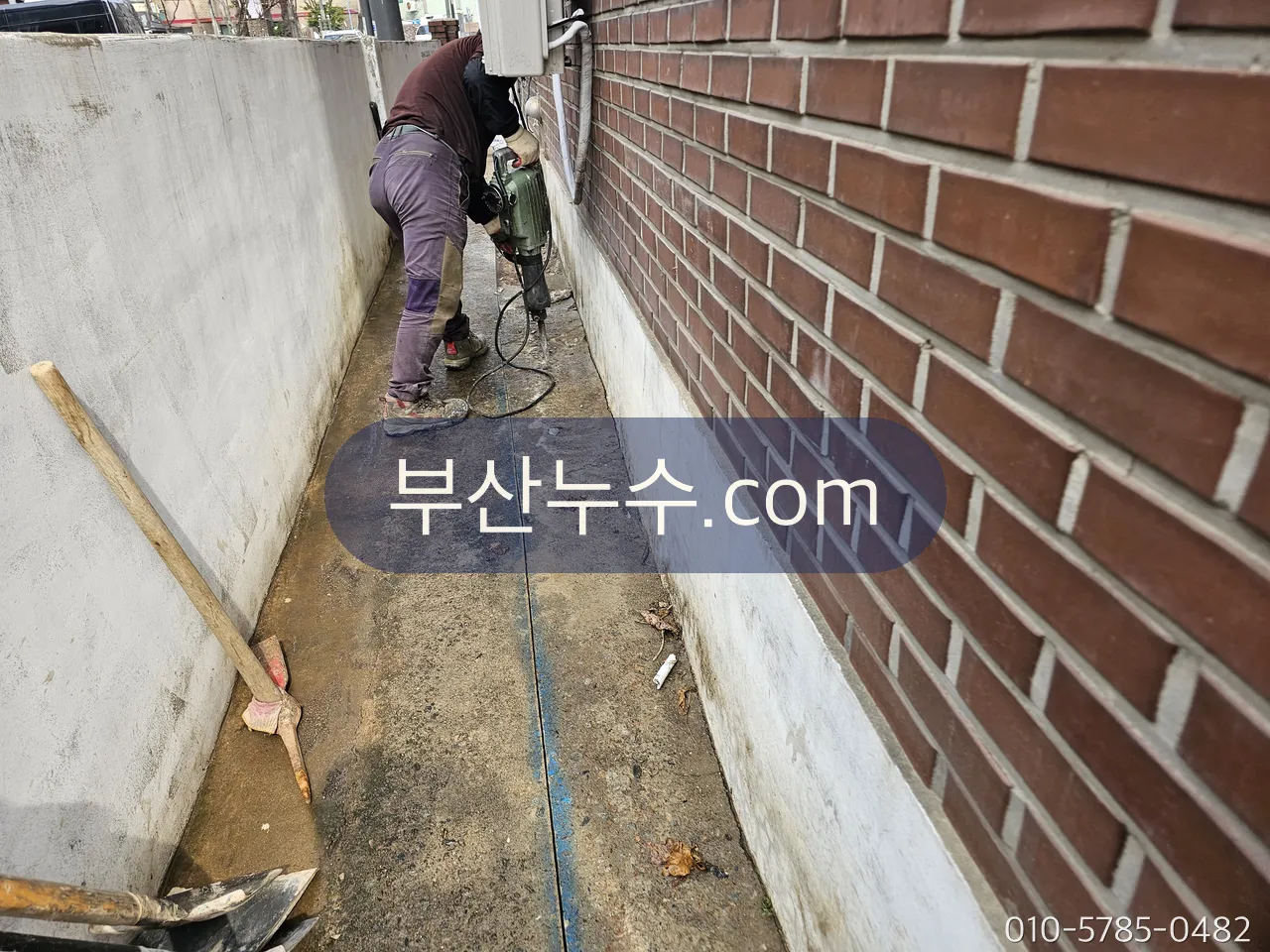 외벽 하단을 따라 파내어 배관을 확인하는 작업