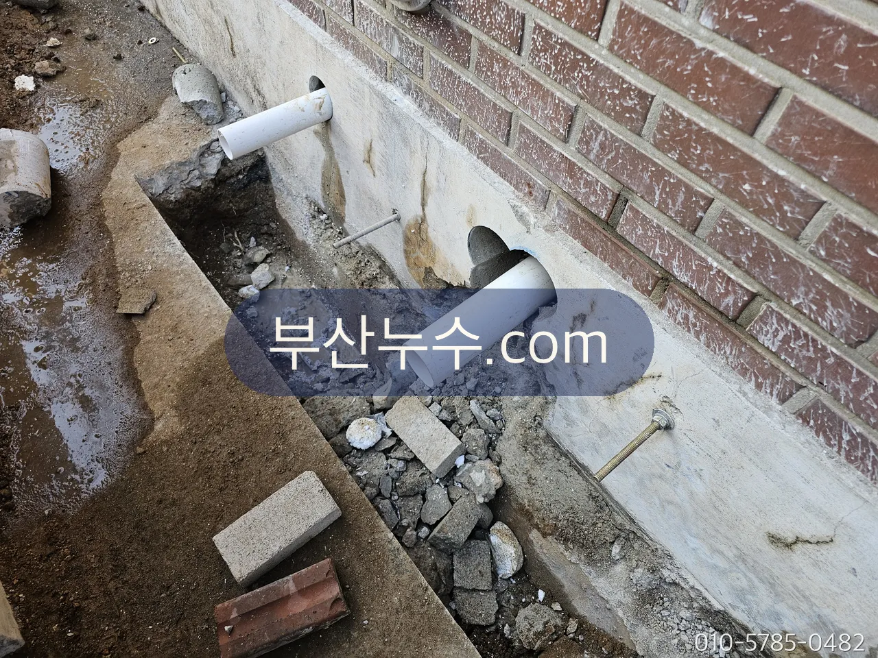 외벽 아래 배관을 드러낸 굴착 현장