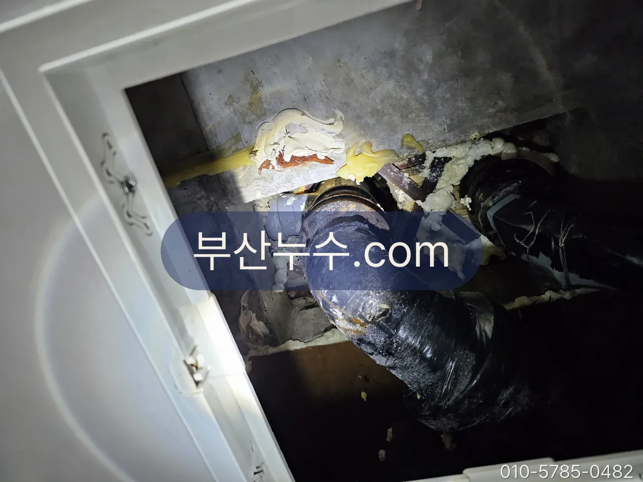 천장 점검구 안으로 위층 배관 하부를 확인하는 모습